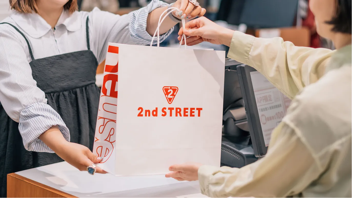 店員為顧客包裝 2nd STREET 購物紙袋