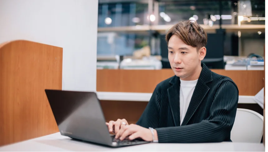 本部教育課副理 方 Sam 使用筆電辦公的照片
